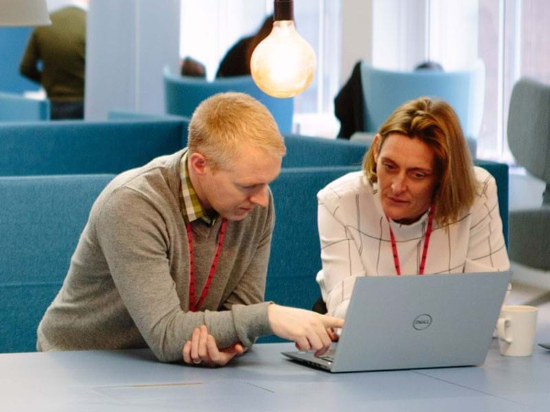 Two people looking at a laptop