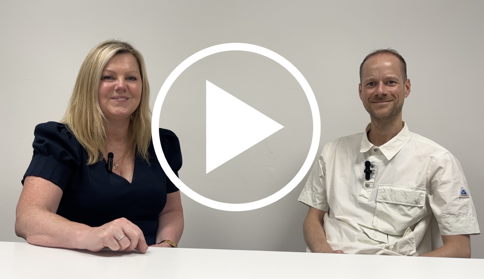 Grace Watson and Richard Walker sat at a table together with a play button overlayed