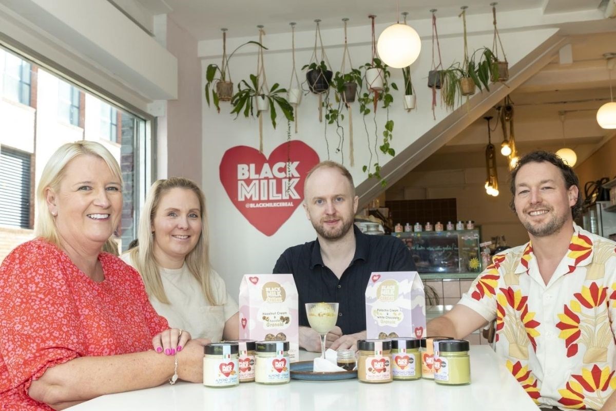 Founder and employees of Black Milk, a GC Business Finance client, sitting around a table with their products on
