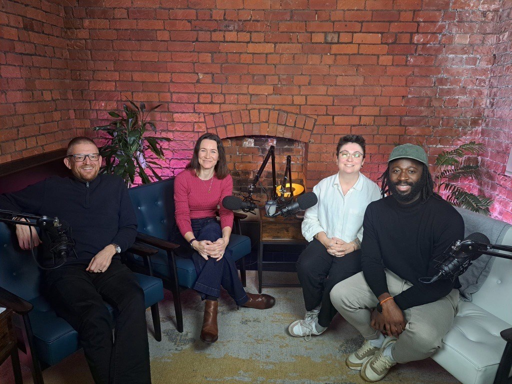 Four colleagues in a podcast recording studio 