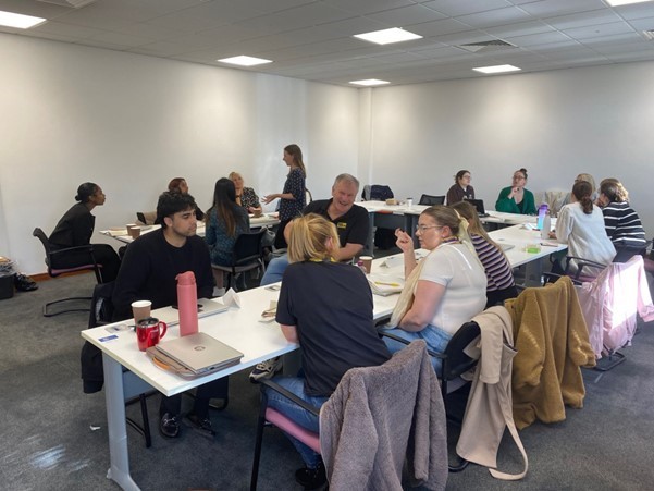 Colleagues sat around a table completing carbon literacy training 