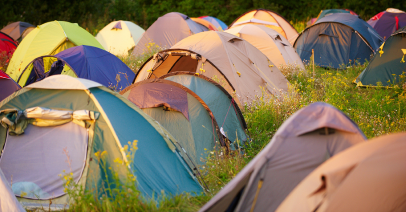 Photo of lots of different coloured tents close together in a field