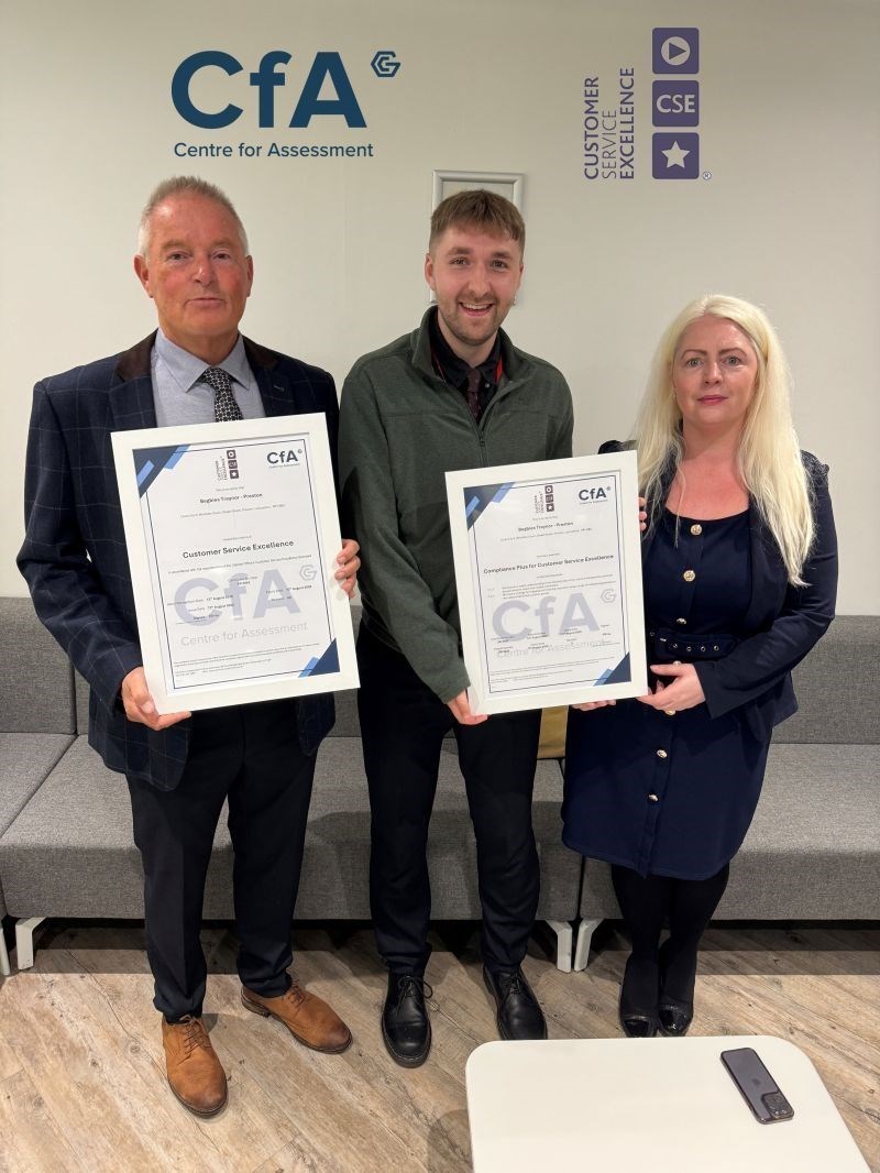 Two Centre for Assessment clients holding their certificates with a colleague