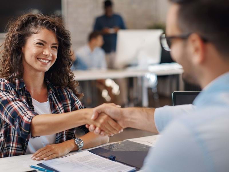 Man and woman shaking hands and smiling