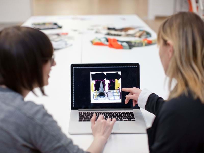 Image of 2 people looking at a laptop screen
