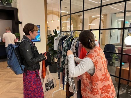Colleague talking to a visitor at the clothes swap