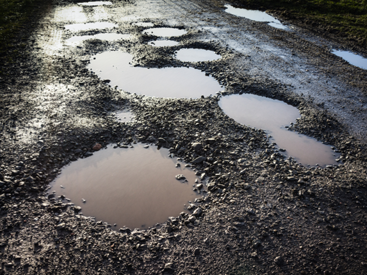 Image of multiple pot holes in a road  Image of multiple pot holes in a road